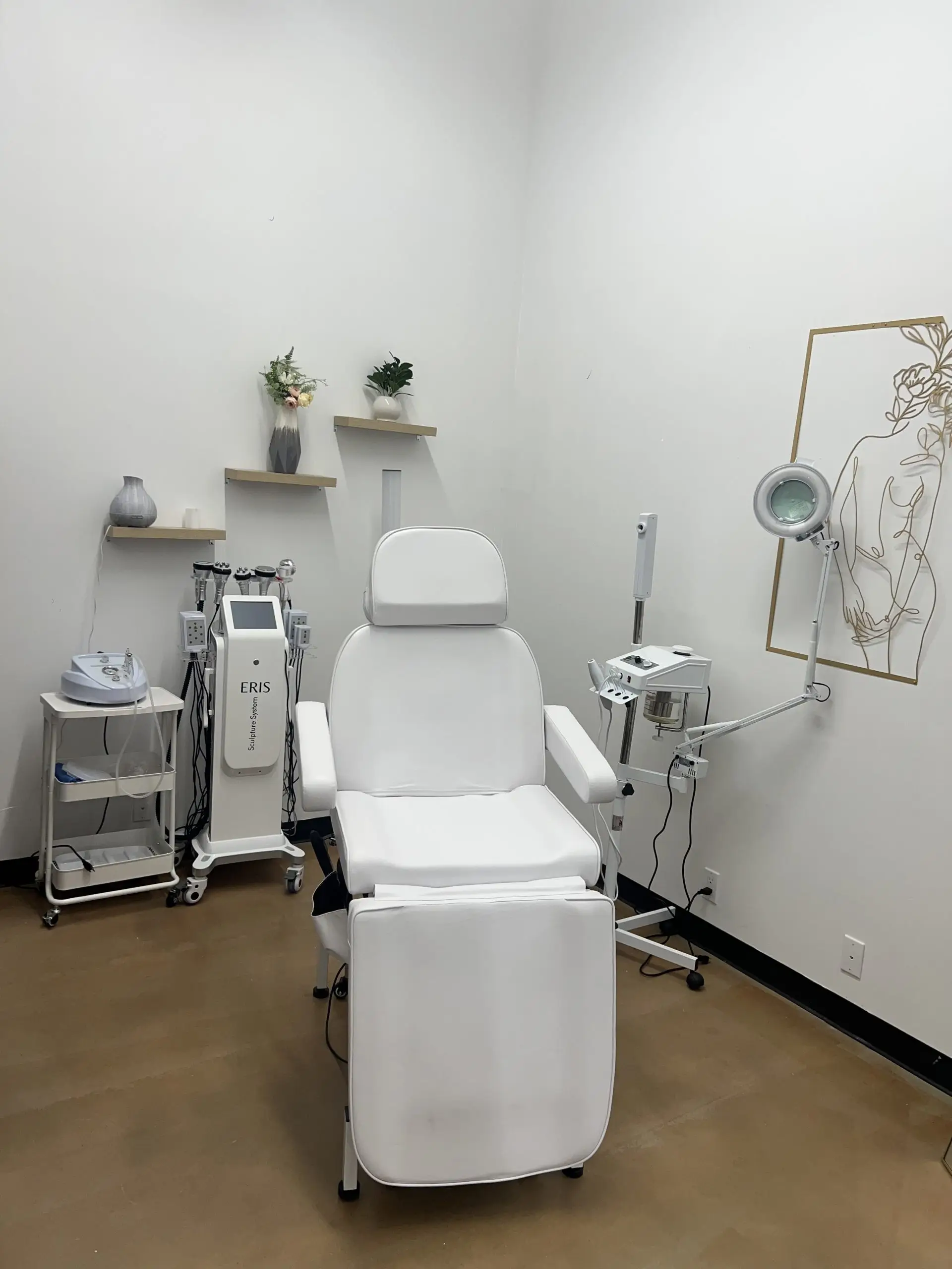 Private esthetic treatment suite featuring a white treatment chair, aesthetic equipment, and decorative elements.